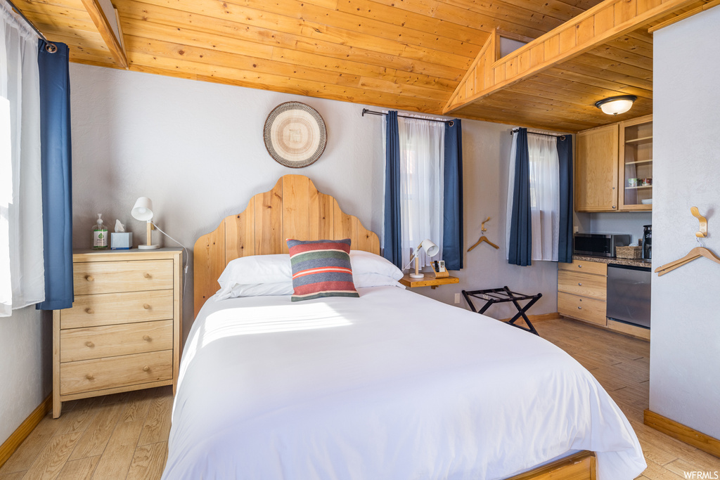 Bedroom featuring wood ceiling, lofted ceiling, and light hardwood / wood-style floors