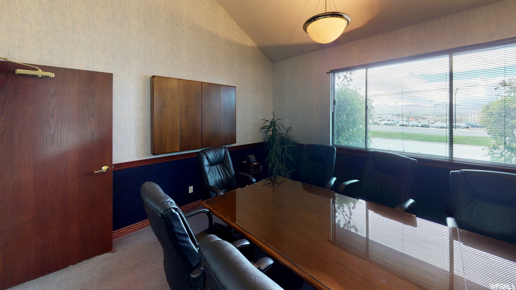 Carpeted office space featuring vaulted ceiling