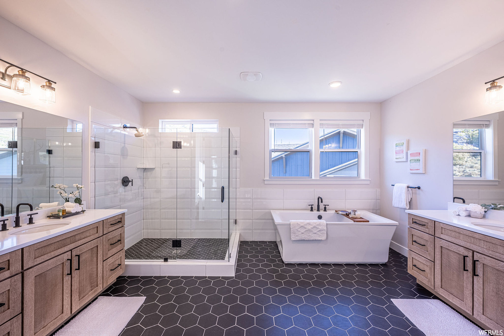 Bathroom with double sink, a healthy amount of sunlight, tile floors, and independent shower and bath