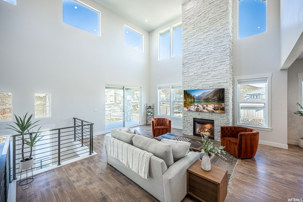 Living room with a wealth of natural light, a fireplace, and hardwood floors