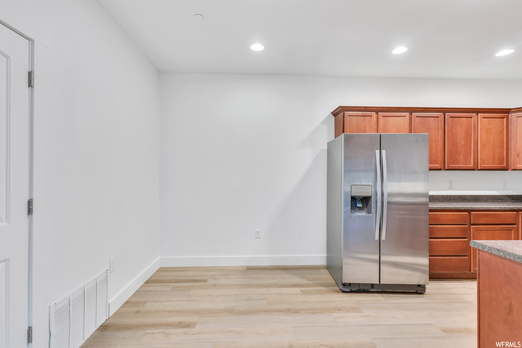 Kitchen featuring light hardwood flooring and stainless steel refrigerator with ice dispenser
