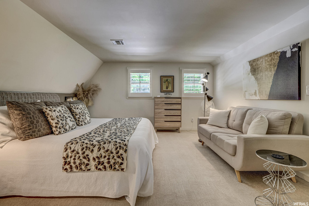 Bedroom featuring vaulted ceiling and light colored carpet
