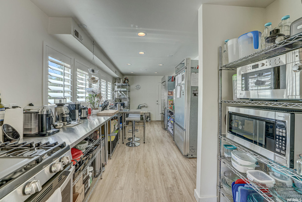 Kitchen featuring appliances with stainless steel finishes and light hardwood flooring