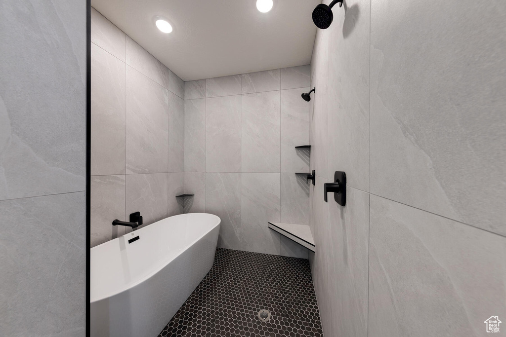Bathroom featuring a tile shower and tile walls