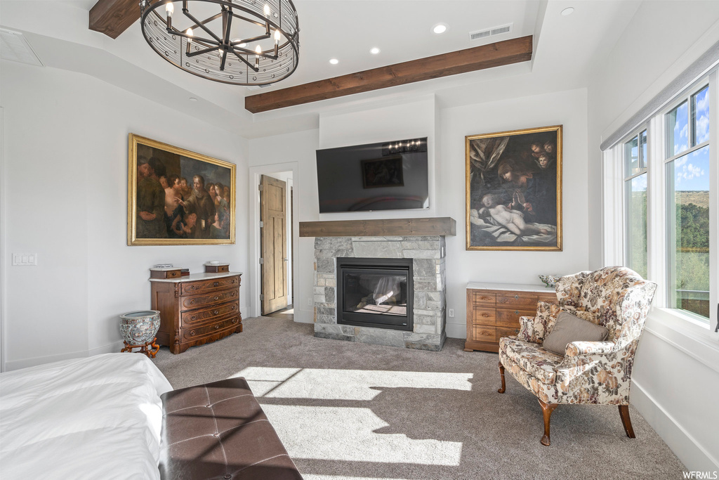Carpeted living room featuring a raised ceiling, a notable chandelier, beamed ceiling, and a fireplace