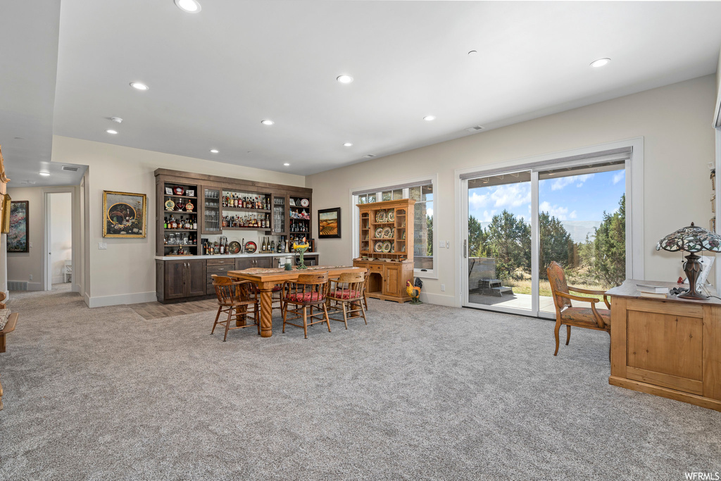 Dining space featuring bar and light carpet