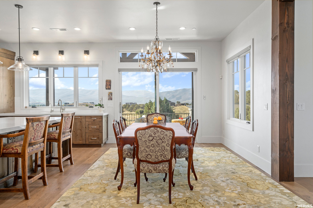 Dining space featuring an inviting chandelier, light hardwood flooring, and a mountain view