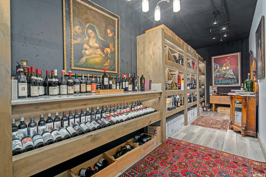 Wine room with bar area and hardwood flooring