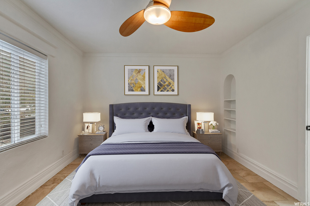Bedroom featuring light tile flooring, crown molding, and ceiling fan