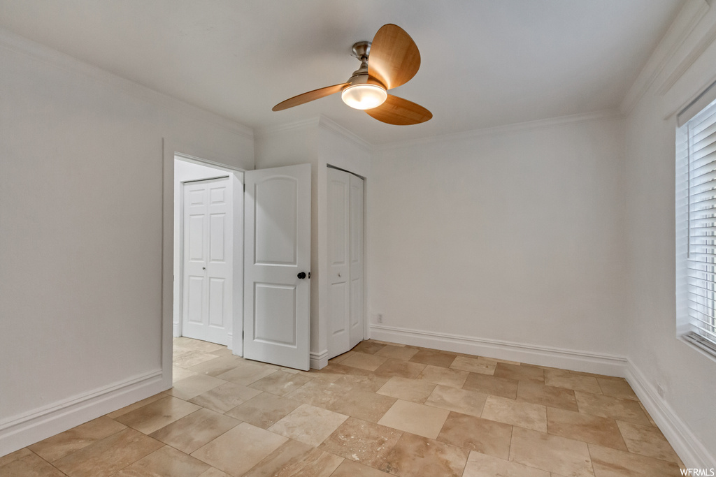 Unfurnished room with crown molding, ceiling fan, and light tile floors