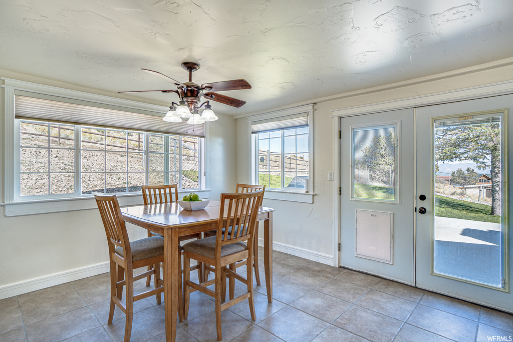 Tiled dining room with french doors and ceiling fan