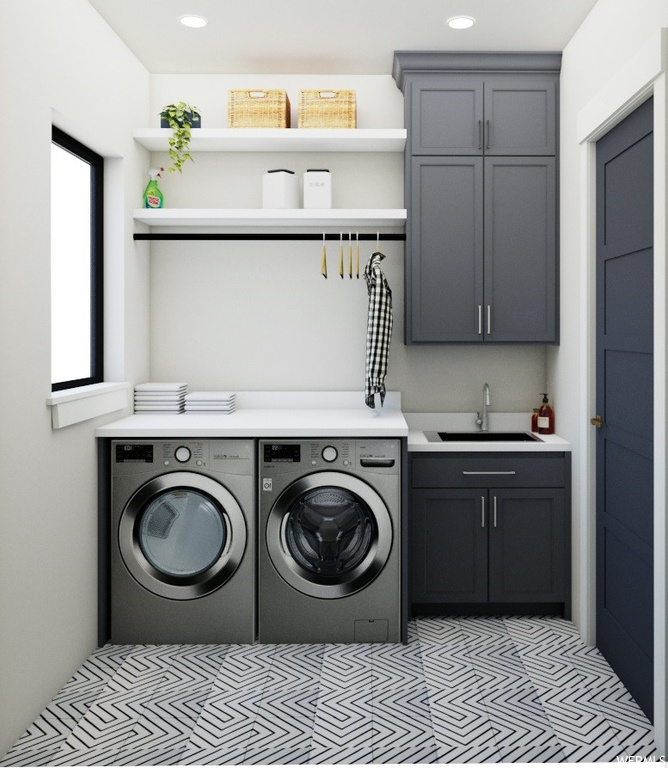 Laundry room with washing machine and dryer, light carpet, cabinets, and sink