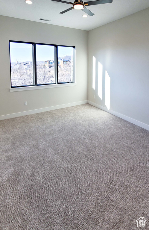 Empty room with ceiling fan, light carpet, and a healthy amount of sunlight