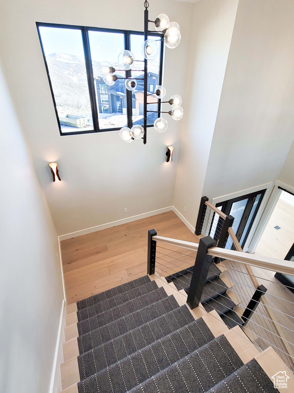 Stairway featuring light hardwood / wood-style floors and a chandelier