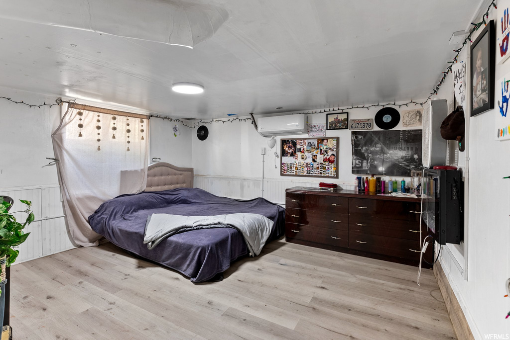 Hardwood floored bedroom with a wall unit AC