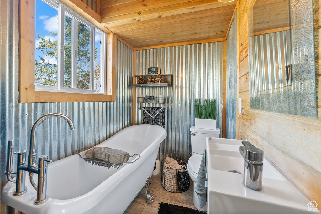 Bathroom with wooden ceiling, sink, toilet, and a bath