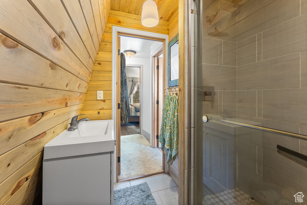Bathroom featuring oversized vanity, walk in shower, wooden walls, tile floors, and wooden ceiling