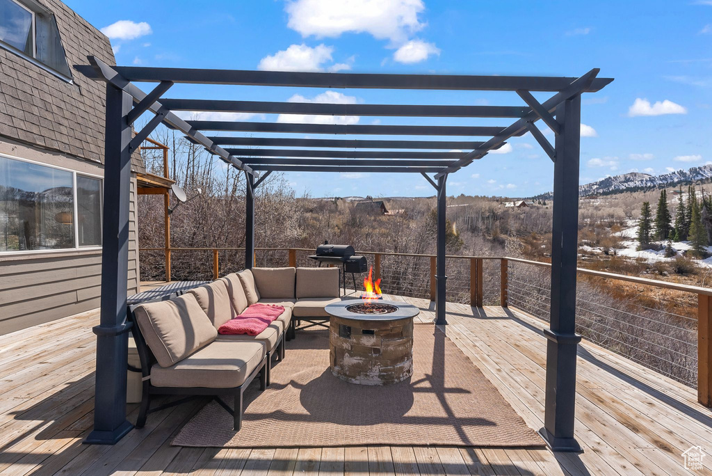 View of patio / terrace featuring a wooden deck, a pergola, and an outdoor living space with a fire pit