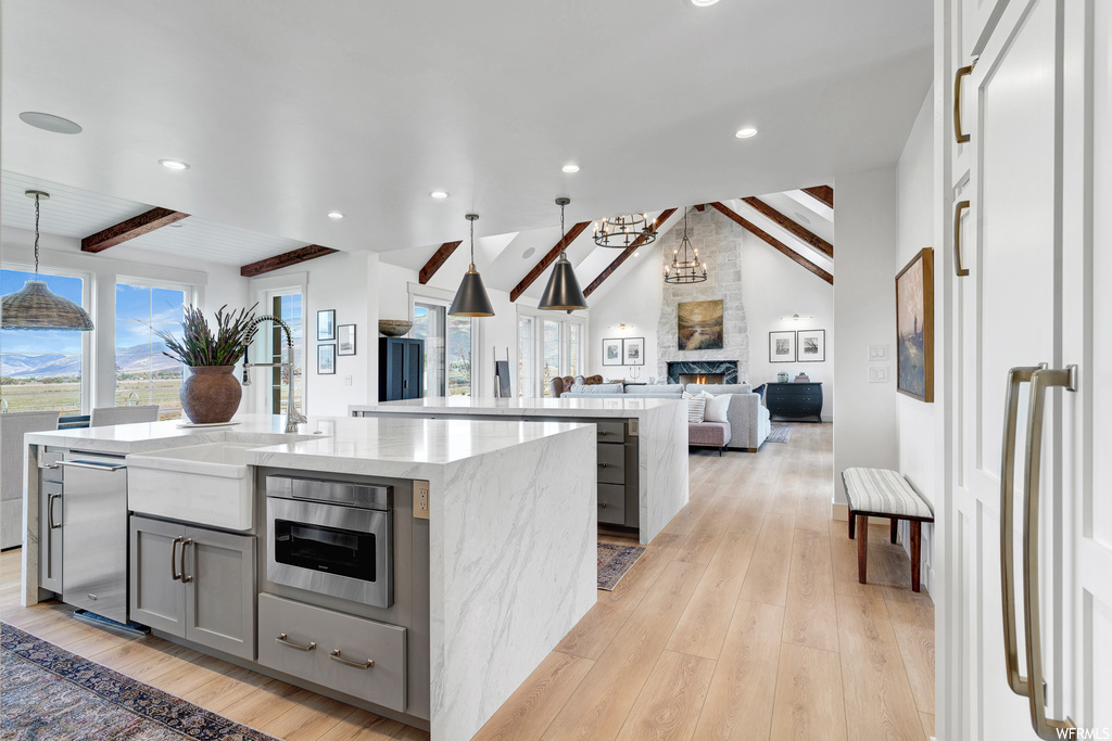 Kitchen featuring light hardwood floors, beam ceiling, and pendant lighting