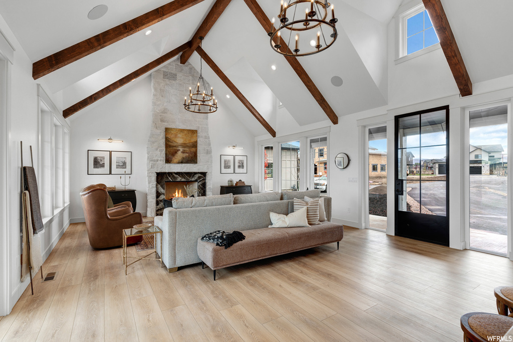Hardwood floored living room with an inviting chandelier and vaulted ceiling high