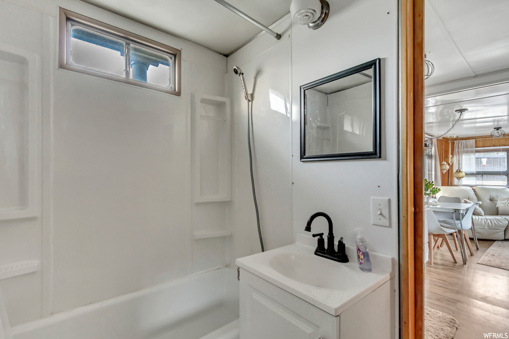 Bathroom with wood-type flooring, vanity, and shower / bathtub combination