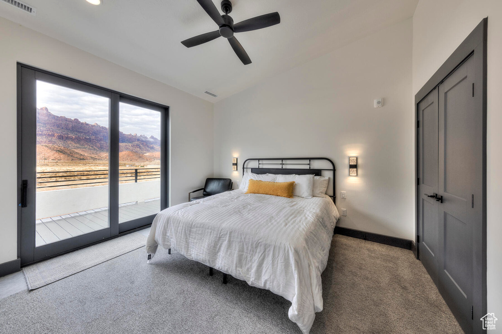 Bedroom featuring access to outside, ceiling fan, vaulted ceiling, a mountain view, and light carpet