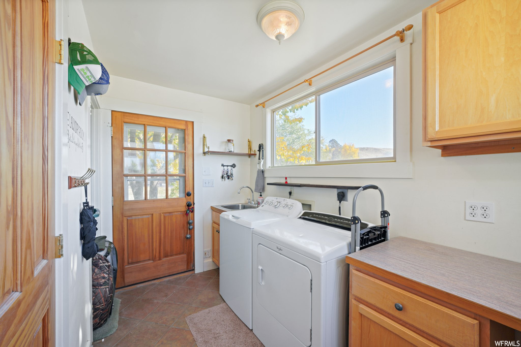 Laundry room featuring cabinets, a wealth of natural light, hookup for an electric dryer, and separate washer and dryer