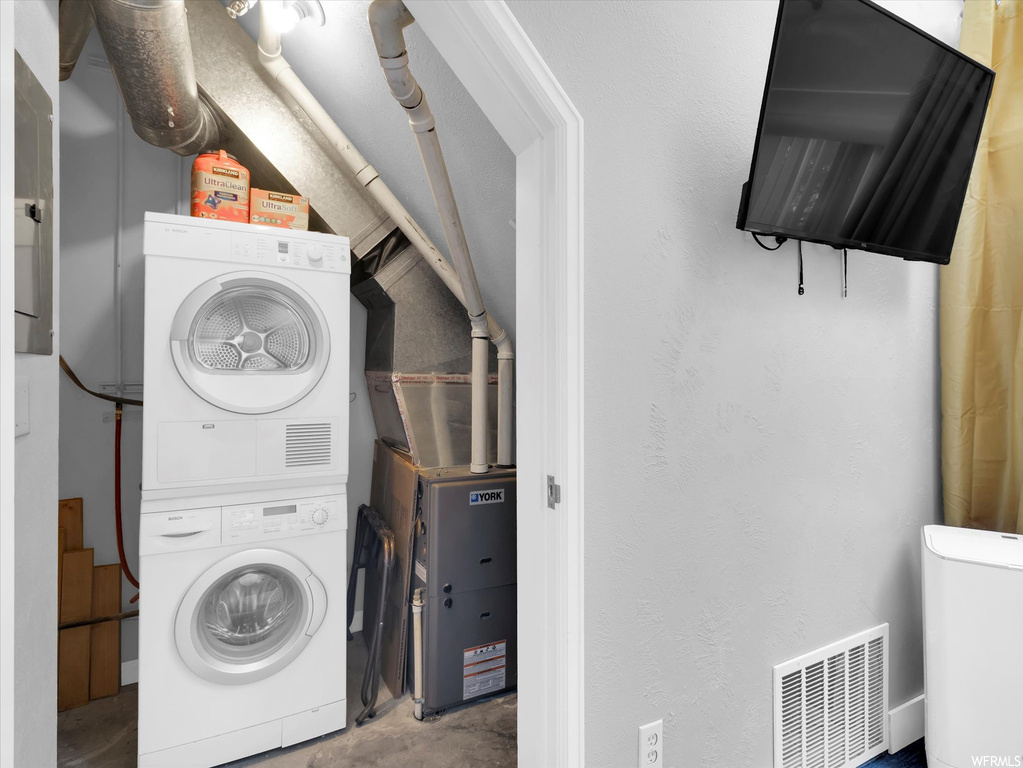 Laundry room with stacked washing maching and dryer