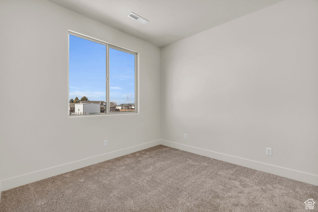 Unfurnished room featuring light carpet