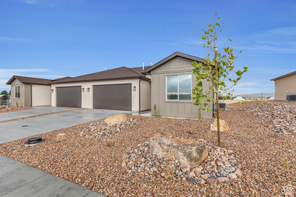 Ranch-style home featuring a garage and central air condition unit