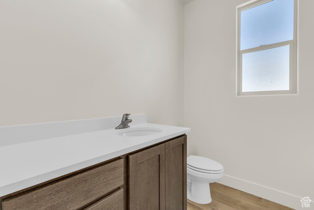 Bathroom featuring vanity, toilet, and hardwood / wood-style flooring