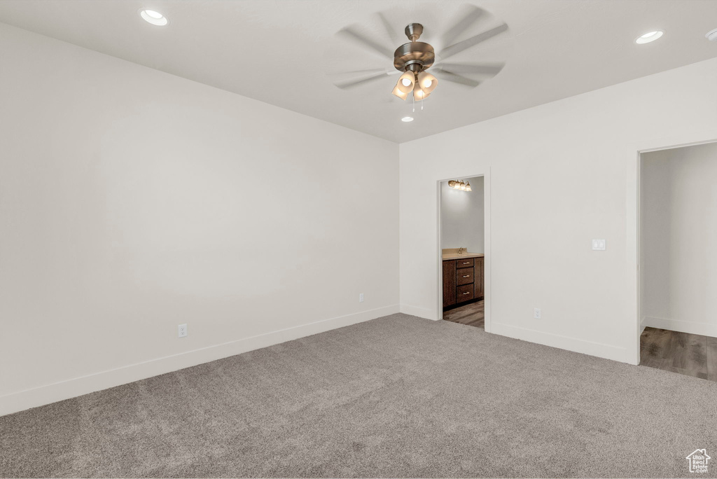 Spare room with dark colored carpet and ceiling fan