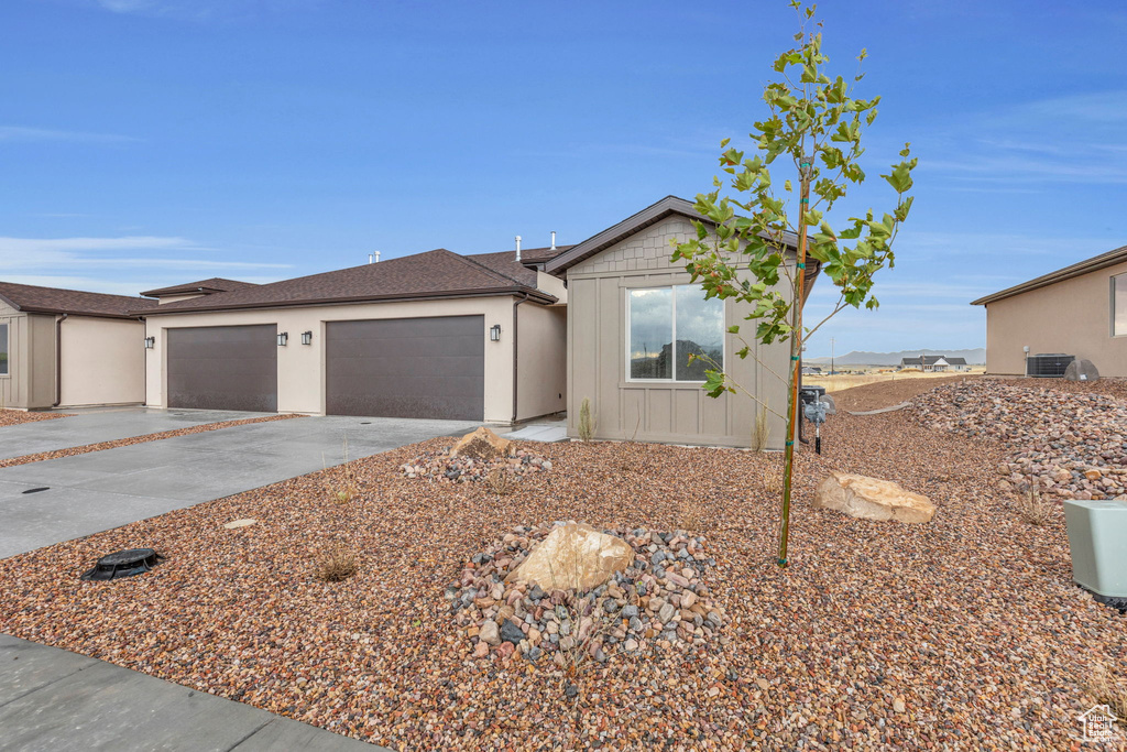 Ranch-style home featuring a garage and central AC