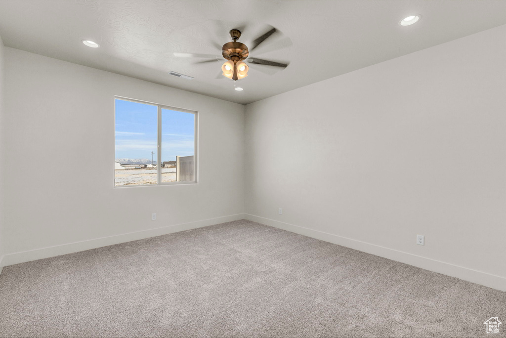 Carpeted empty room featuring ceiling fan