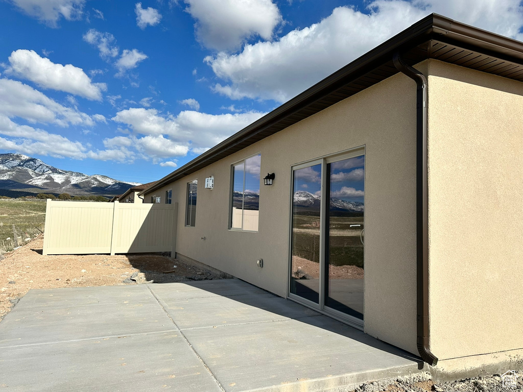 View of property exterior with a patio area and a mountain view