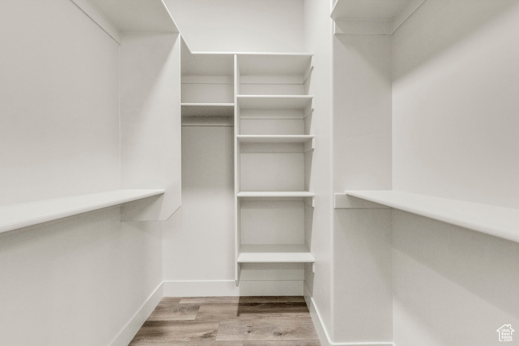 Spacious closet with light hardwood / wood-style flooring