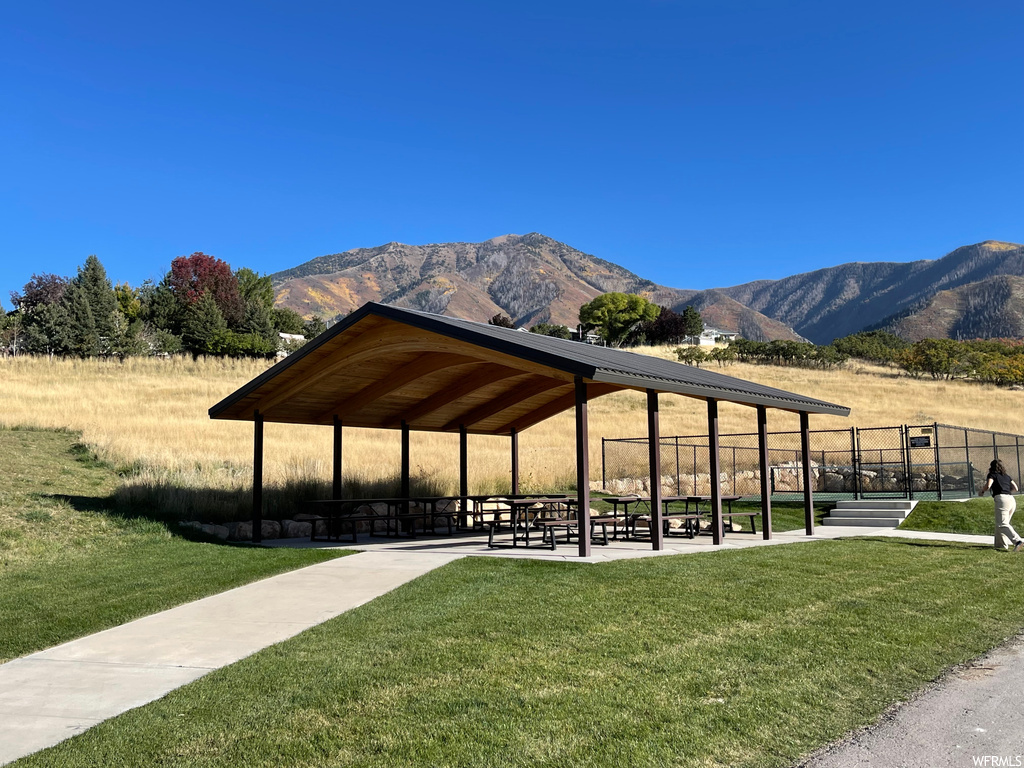 View of property's community with a mountain view and a lawn