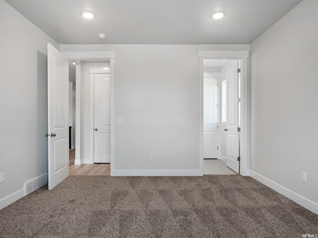 Unfurnished bedroom with light colored carpet