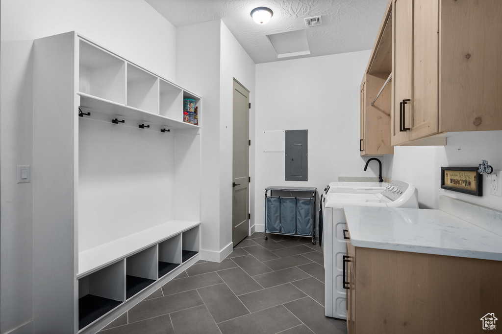Mudroom featuring a textured ceiling, dark tile flooring, and independent washer and dryer