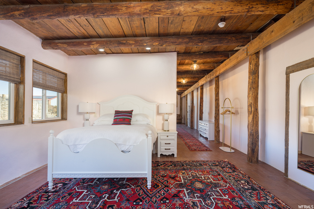 Bedroom with wooden ceiling, beam ceiling, and dark hardwood / wood-style flooring