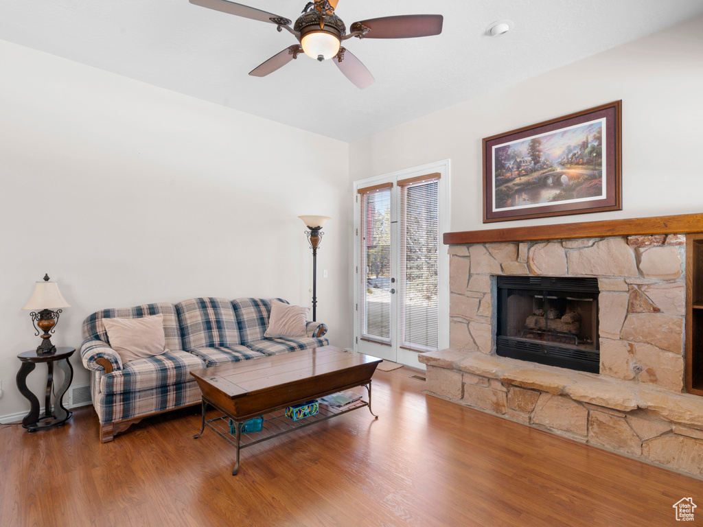 Living room featuring a fireplace, hardwood / wood-style flooring, and ceiling fan
