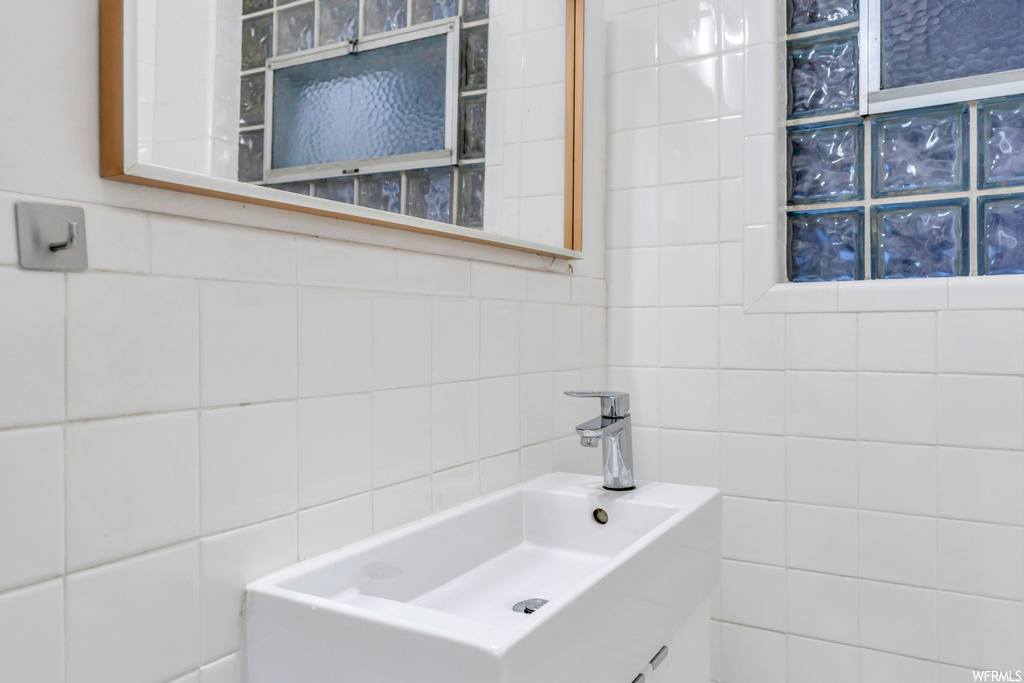 Bathroom featuring tile walls and sink