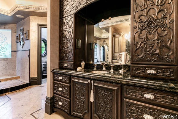 Bathroom featuring crown molding, vanity, and tile flooring