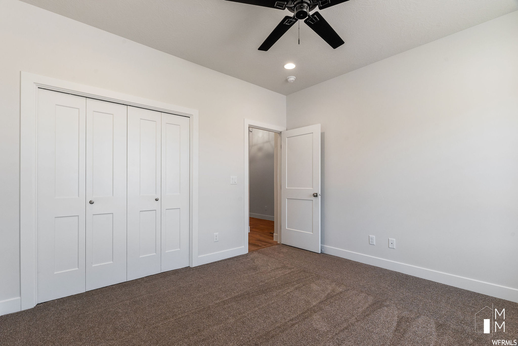 Unfurnished bedroom with ceiling fan, carpet flooring, and a closet