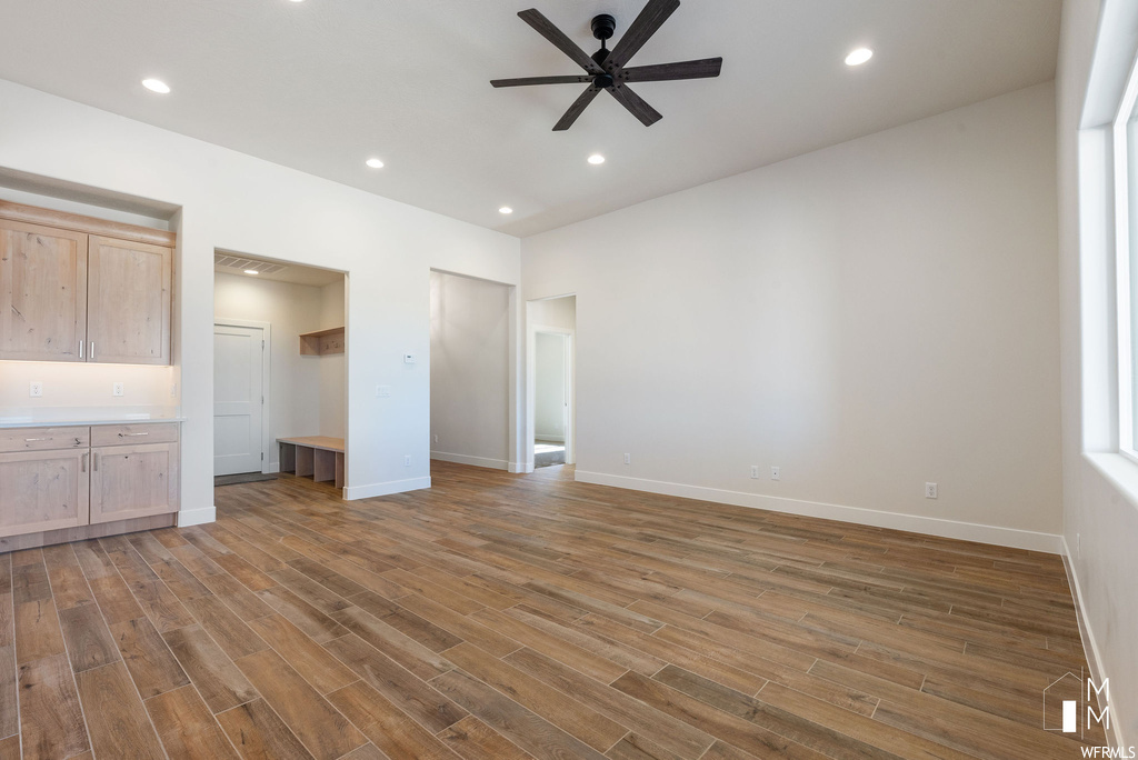 Unfurnished bedroom featuring connected bathroom, ceiling fan, and hardwood / wood-style flooring