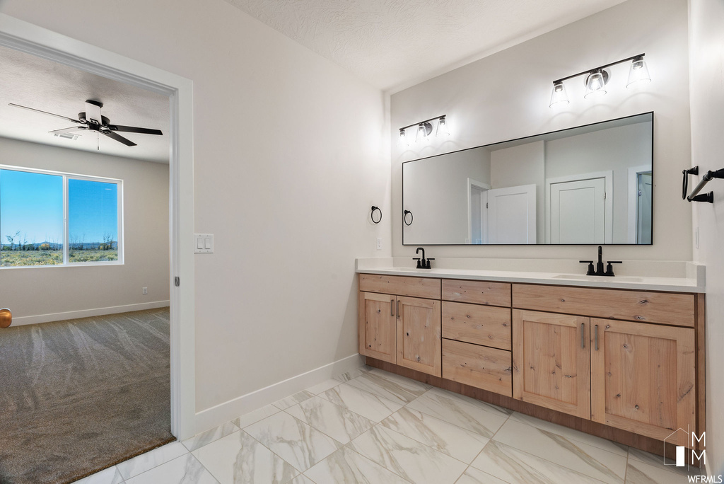 Bathroom featuring double vanity, ceiling fan, and tile flooring