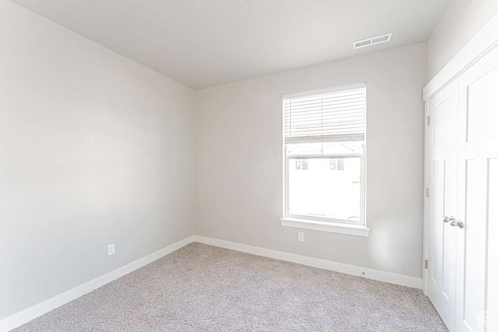 Unfurnished room featuring a wealth of natural light and light colored carpet