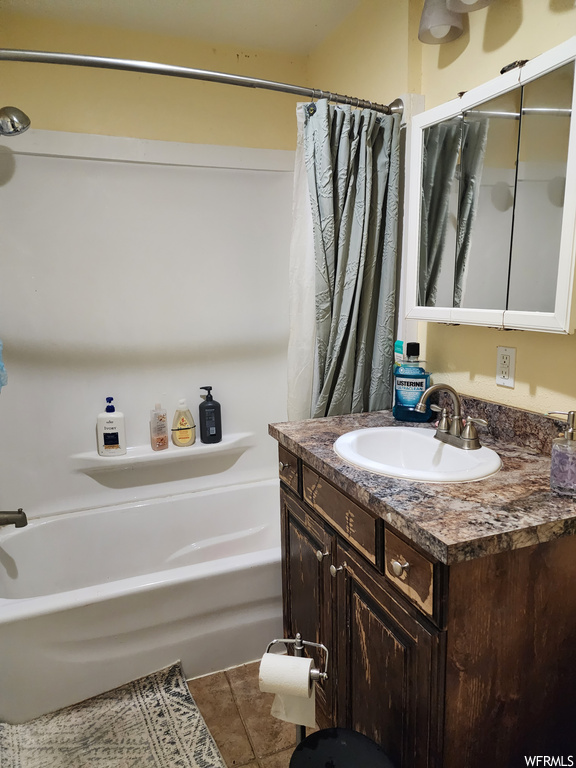 Bathroom with vanity, shower / tub combo with curtain, and tile flooring