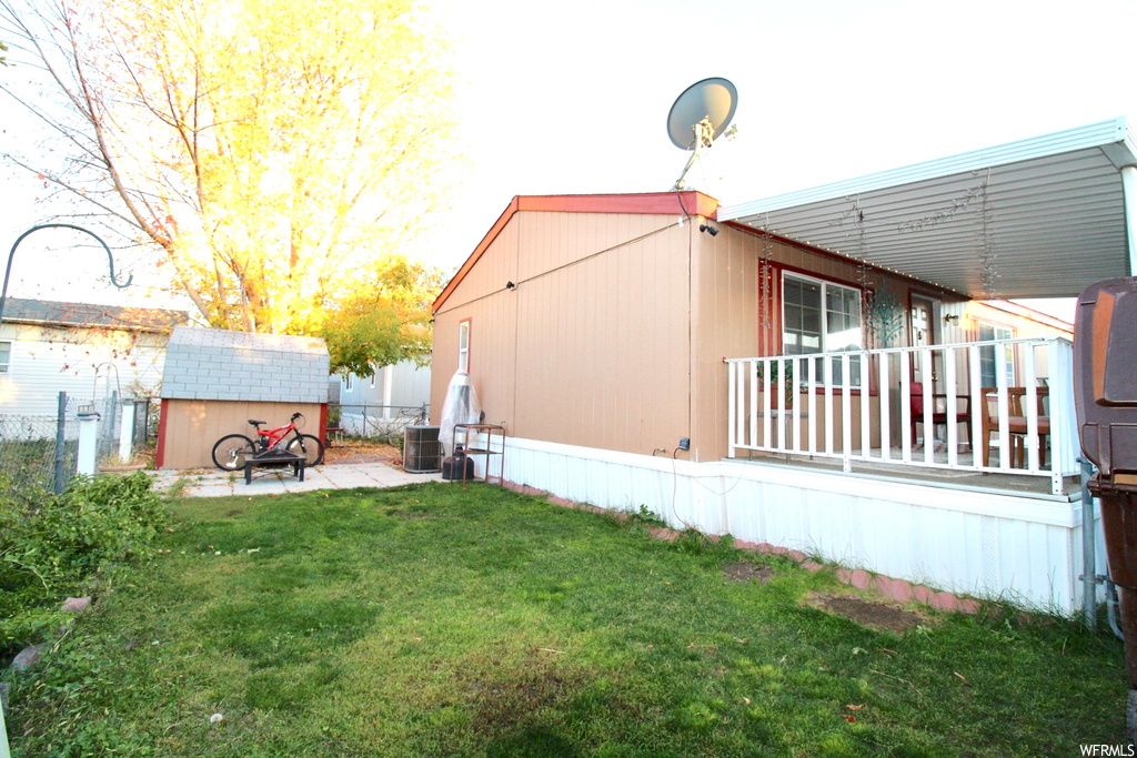 View of yard with central AC, a patio, and a storage unit