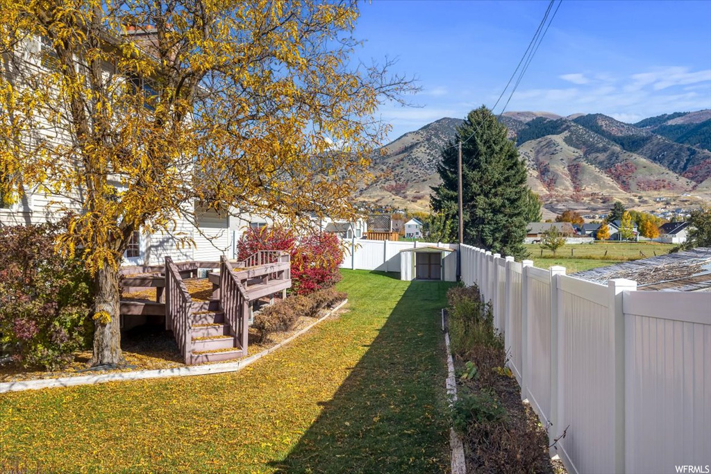 View of yard featuring an outdoor structure and a deck with mountain view